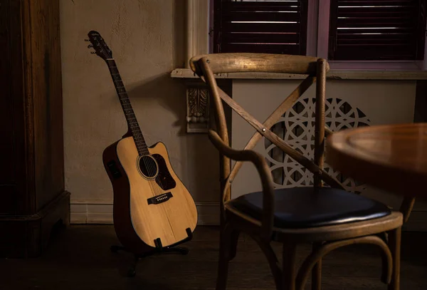 gitar iç kısımda ve sandalyede