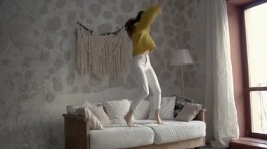 Sarı kazaklı esmer kız eğleniyor.