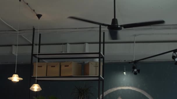 Czarny wentylator pracuje na suficie w stylowej odnowionej kawiarni poddaszu — Wideo stockowe