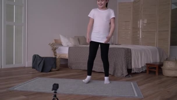 Dziewczyna dziecko nadaje kurs online i pisze vlog o gimnastyce w domu — Wideo stockowe