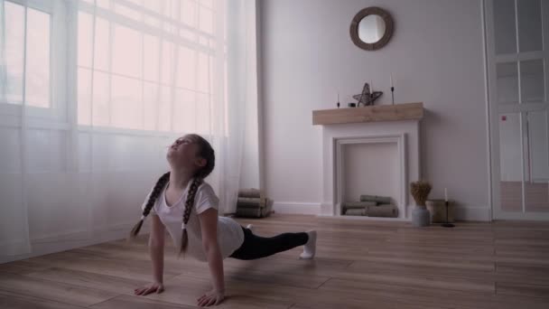 Девочка-ребенок транслирует онлайн-курс и пишет блог о гимнастике дома — стоковое видео