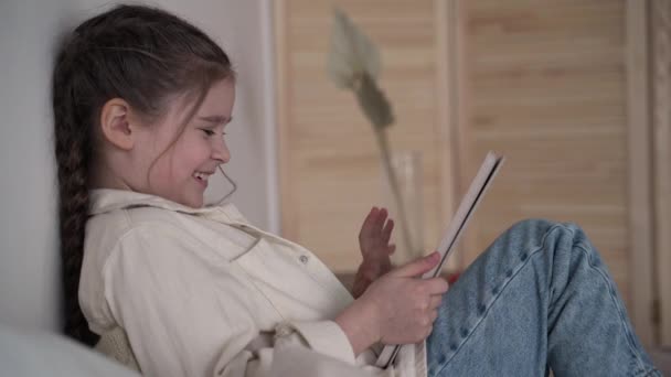 Menina jogando um jogo no tablet móvel. divertindo-se em férias em casa close-up — Vídeo de Stock