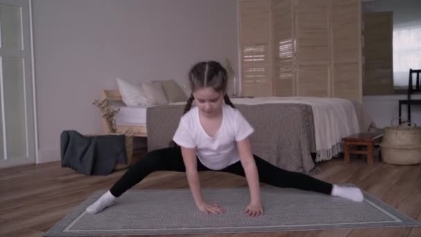 Menina criança transmite um curso on-line e escreve um vlog sobre ginástica em casa — Vídeo de Stock