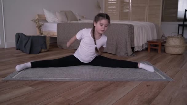 Menina criança transmite um curso on-line e escreve um vlog sobre ginástica em casa — Vídeo de Stock