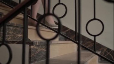 Granit merdivenlerden yavaş çekimde inen ayakkabılı kız.