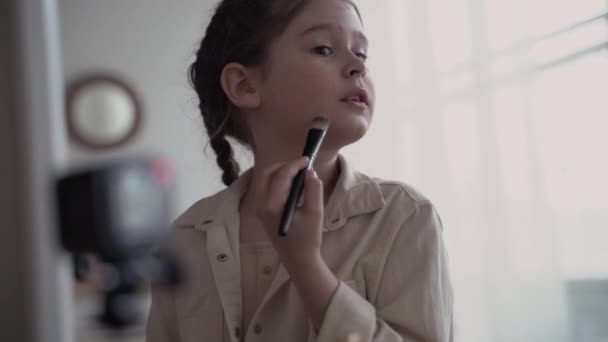 Niña blogger infantil transmite en vivo en línea y escribe blog sobre maquillaje adolescente y cosméticos. primer plano — Vídeos de Stock