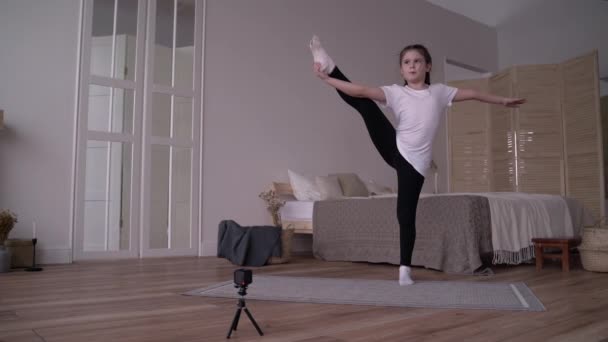 Kız çocuğu evde jimnastik dersleri hakkında bir blog kaydediyor. — Stok video