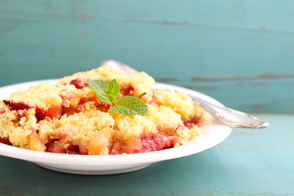 Crumble com morangos em placa branca — Fotografia de Stock