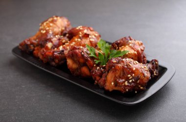 Soya soslu tavuk kanadı, bal ve susamlı. Geleneksel Asya tarifi. Koyu arkaplan.