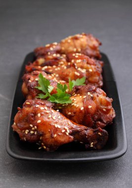 Soya soslu tavuk kanadı, bal ve susamlı. Geleneksel Asya tarifi. Koyu arkaplan.