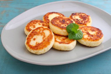 Naneli, yakın plan manzaralı bir tabakta süzme peynirli krep ya da şurup. Rus, Ukrayna mutfağı. Sağlıklı lezzetli kahvaltı.. 