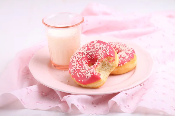 ピンクのアイシングおよびミルクと甘いドーナツ — ストック写真