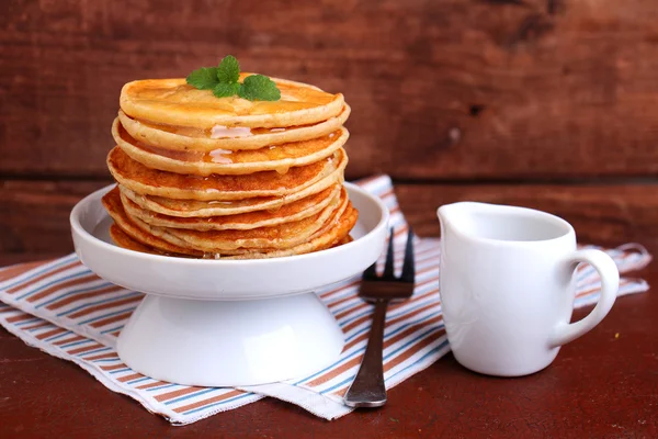 Pancakes with honey decorated with mint leaf — Stock Photo, Image