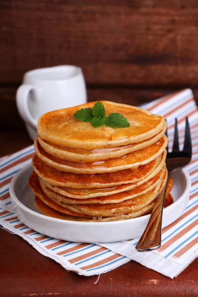 Pancakes with honey decorated with mint leaf — Stock Photo, Image