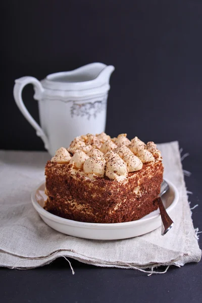 Cake with chocolate and pitcher of milk — Stock Photo, Image