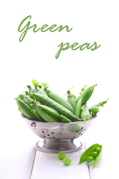 Young peas in a metal colander — Stock Photo, Image