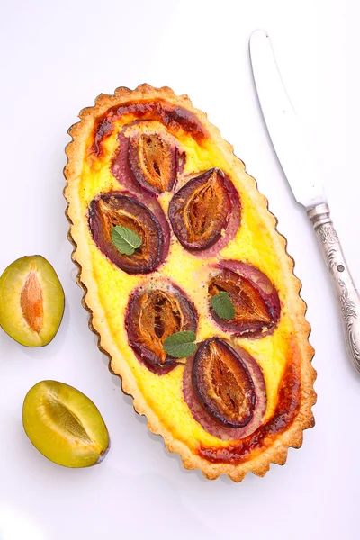 Tart of pastry with plums on a white background — Stock Photo, Image