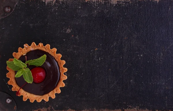 Cake met chocolade en kersen op een zwarte achtergrond — Stockfoto