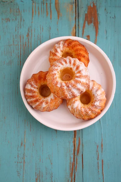 Zelfgemaakte muffins met poedersuiker op een plaat — Stockfoto