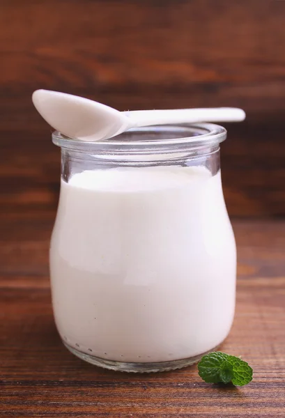 Jar of yogurt and a spoon — Stock Photo, Image
