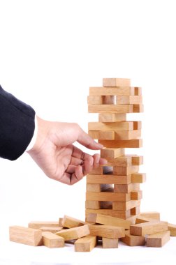 Ahşap oyun (jenga) ile oynarken iş adamı. Beyaz backgro