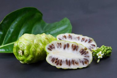 Noni meyvesi ya da Morinda Citrifolia ve yaprağı siyah arka planda izole edilmiş.. 