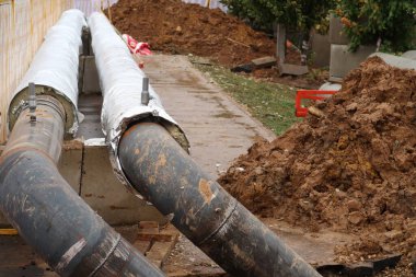 Isı yalıtımı ile kısmen kaplı iki boru, sıcak su ile boru döşeme
