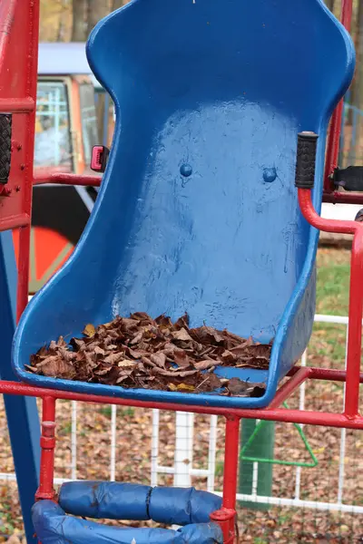 Schaukel Vergnügungspark Für Kinder Sitzend Mit Trockenen Blättern Bedeckt Herbst — Stockfoto