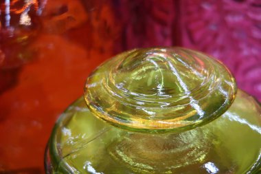 Pembe arka planda antika kapaklı yeşil cam kavanoz, renkli arka plan