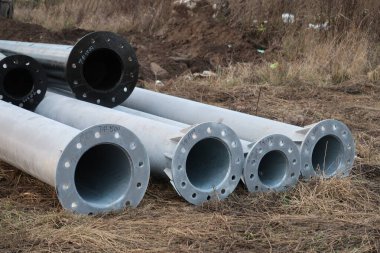 İnşaat metal yapıları nemli zeminde, inşaat sahasında yatıyor.