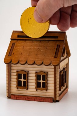 Adamın biri oyuncak bir avroya çikolata koyar Oyuncak bir eve bir kumbara