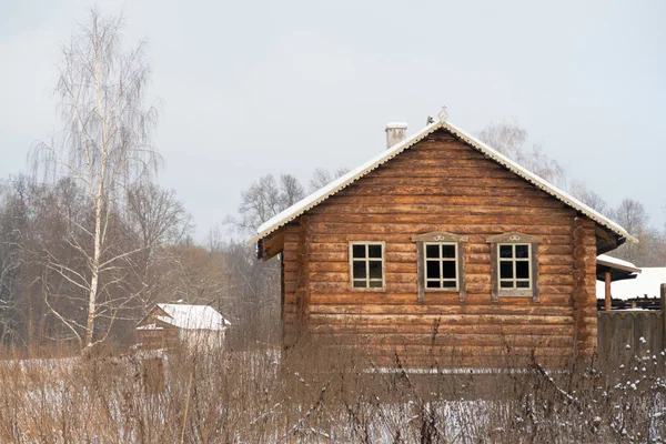 雪に覆われた木々の背景にある森の家 — ストック写真