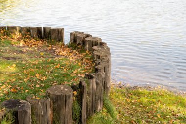 Yerlere, gözlem güvertesine, arka plana saplanmış kütüklerle sahili güçlendirmek