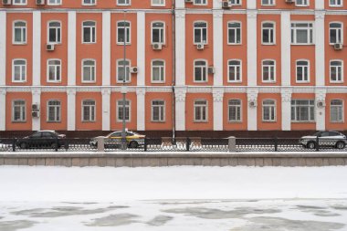Karla kaplı bir yaya yolu ve Drainage Kanalı 'nın setinde metal bir çit, Maly Krasnokholmsky Köprüsü görünür, bulutlu, kış mevsiminde
