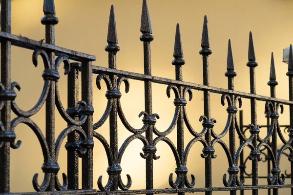 Openwerk Metalen Hek Met Pieken Achtergrond Van Een Lichte Muur — Stockfoto