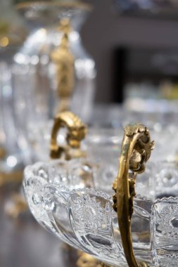 Ön planda güzel sarı metal zımbalarla oyulmuş klasik kristal tabaklar.