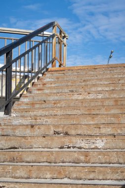 Mavi gökyüzüne uzanan metal parmaklıklı merdiven, yaya geçidi.