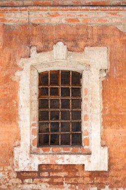 Beyaz taştan pencereli alçıdan bir manastır duvarı, ön cephenin bir parçası.