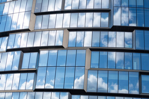 Clouds and blue sky are reflected in the glass facade of a modern building, Kutuzovsky Prospekt, Moscow