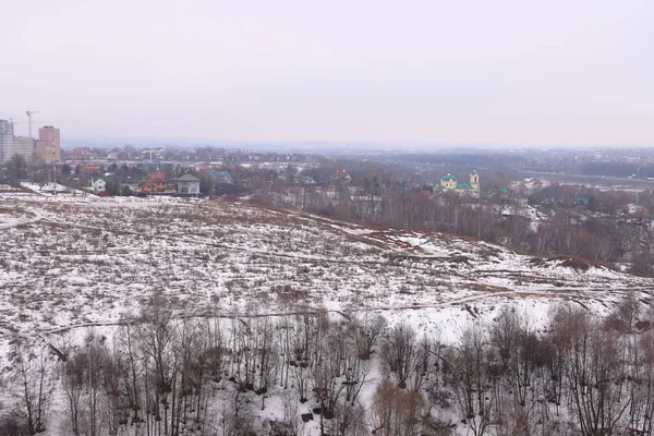 Snow is melting in the fields, village, new building and church, pacifying atmosphere, mood, background