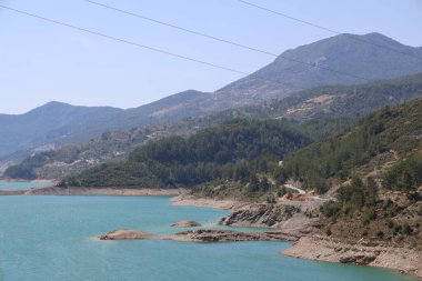 Sarmal kayalık bir sahil ve dağlar, Dim Nehri 'nde bir su deposu, masmavi bir su. Alanya, Nisan 2021