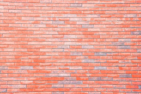 Brick wall, red brick laying, uneven brick surface, reddish background