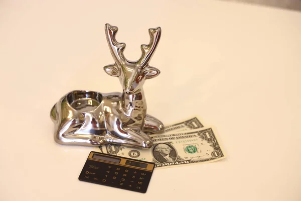 金融の成功 ドル紙幣と計算機の銀の鹿のシンボル — ストック写真