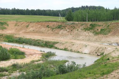 Sel basmış eski bir kum ocağı çimlerle kaplanmış, Moskova bölgesi, Haziran 2021