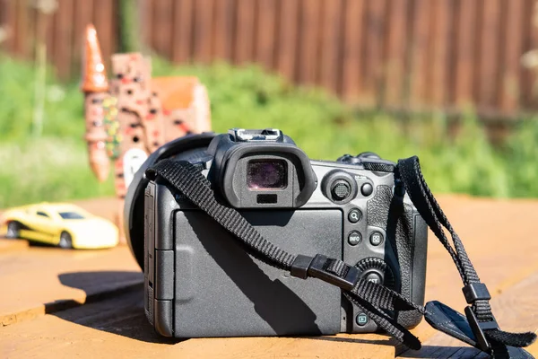 Photo camera against the background of a toy house and a car, freelancer, shooting for photo stocks