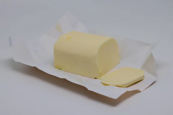 Ein Stück Butter Liegt Auf Einem Ungefalteten Papierpaket Hintergrund — Stockfoto