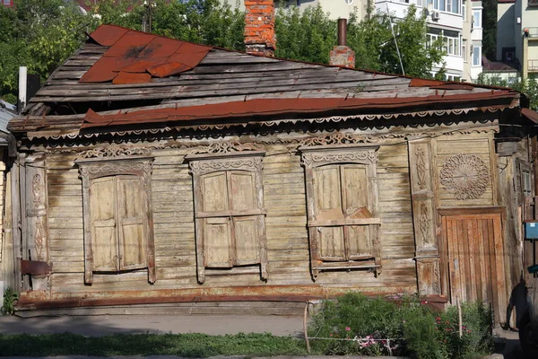 Leaky roof of an old wooden house with closed shutters, Samara, June, 2021