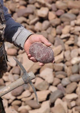 Bir jeologun elinde kaya ve çekiç, bir kızıl kaya örneği, Ağustos 2021