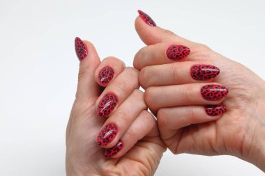 İki kadın eli, parmaklarında cila görünüyor, parlak kırmızı cila.