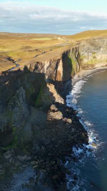 İzlanda 'nın kuzeyindeki kıyı manzarasının havadan görüntüsü dikey 4K